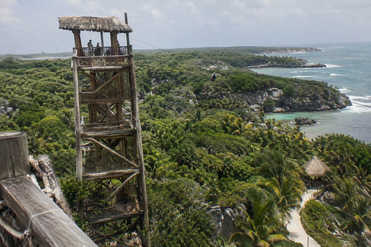 Zipline cables and wooden platform tower above dense tropical jungle canopy