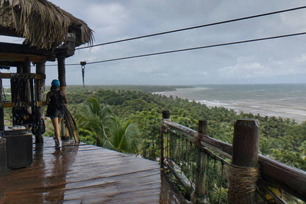 Wooden zipline platform and cables above a wide green valley in the Dominican Republic