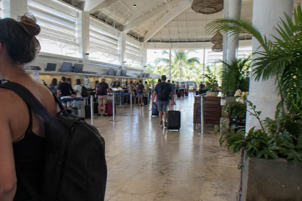 Airline check-in counters in a bright tropical airport terminal