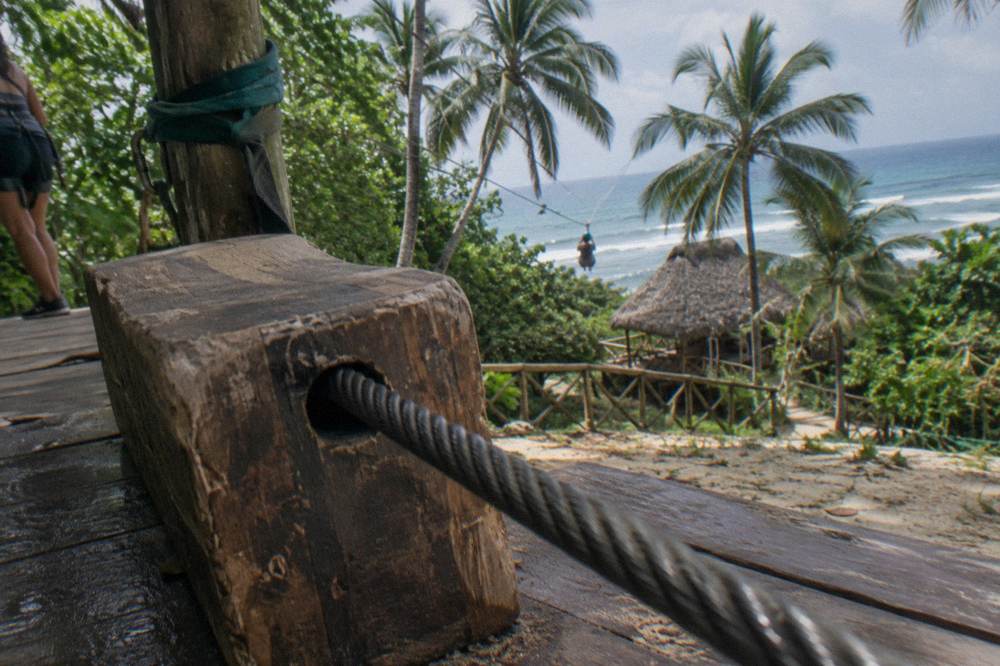 Landing platform with thick zipline cable and wooden braking area in tropical forest