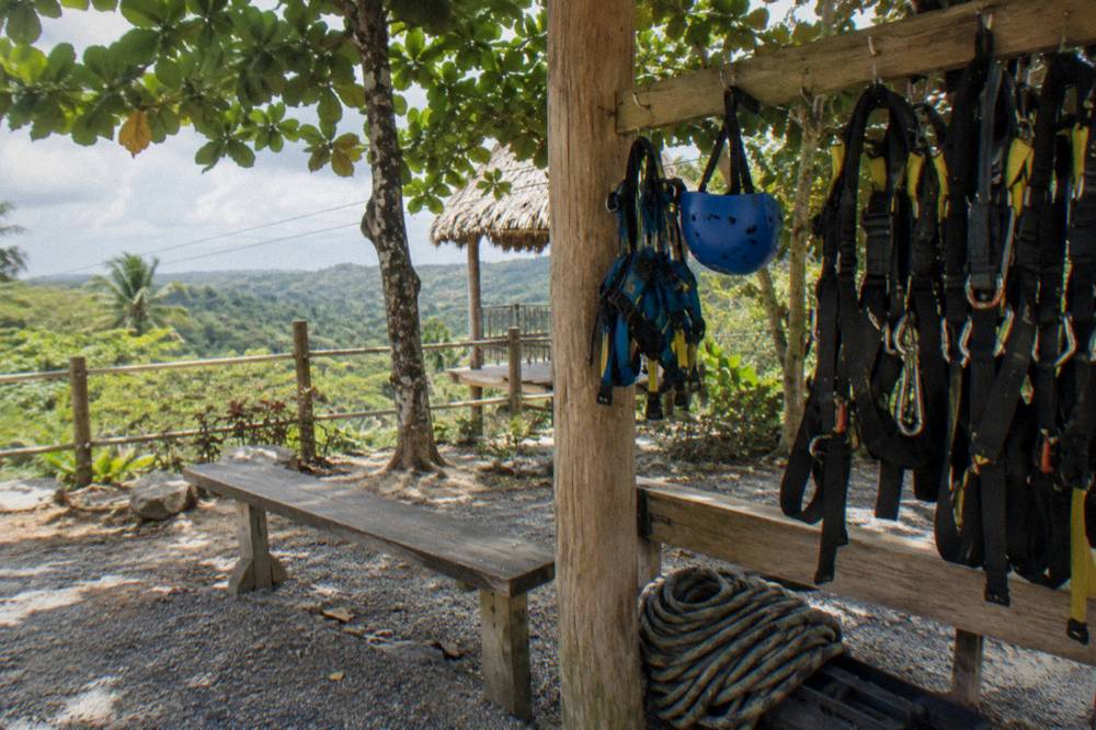 Child-sized zipline harness and helmet hanging on a rack at a jungle course