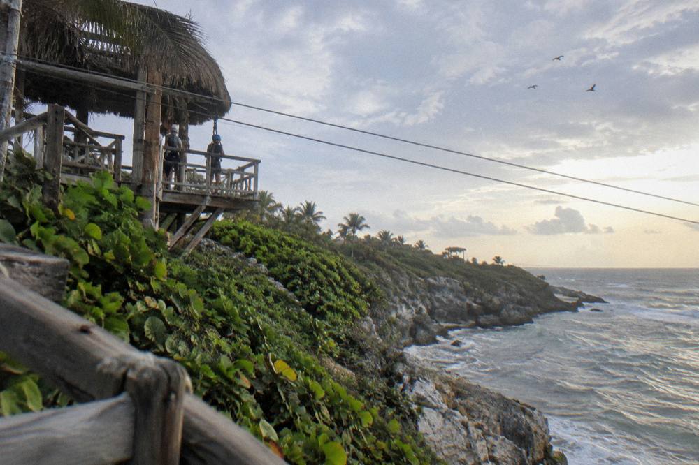 Wooden zipline platform and cables above dense green jungle in the Dominican Republic