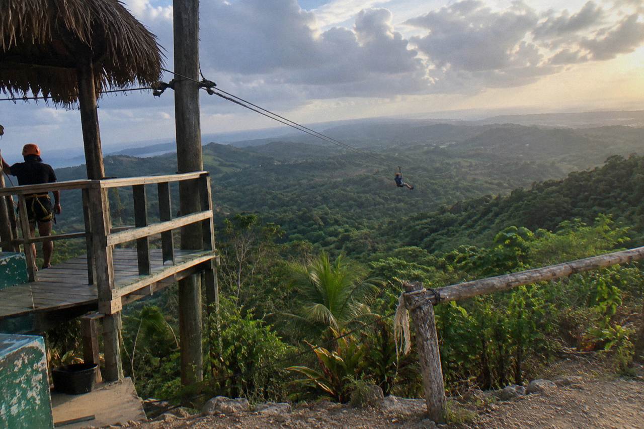 Zipline platform and cables crossing a green jungle canopy in the Dominican Republic