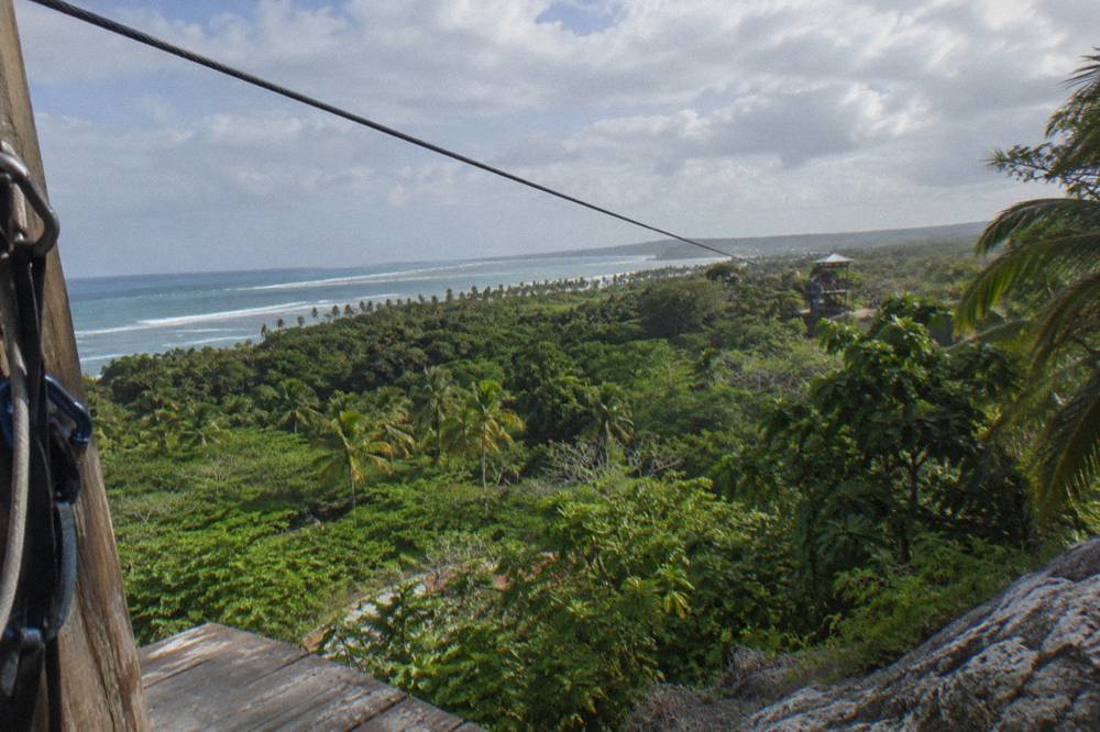 Quiet zipline cable stretching over green tropical valley in soft light
