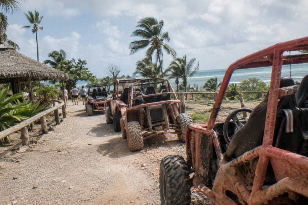 Buggies parked on a dirt trail beside jungle at a Punta Cana adventure ranch