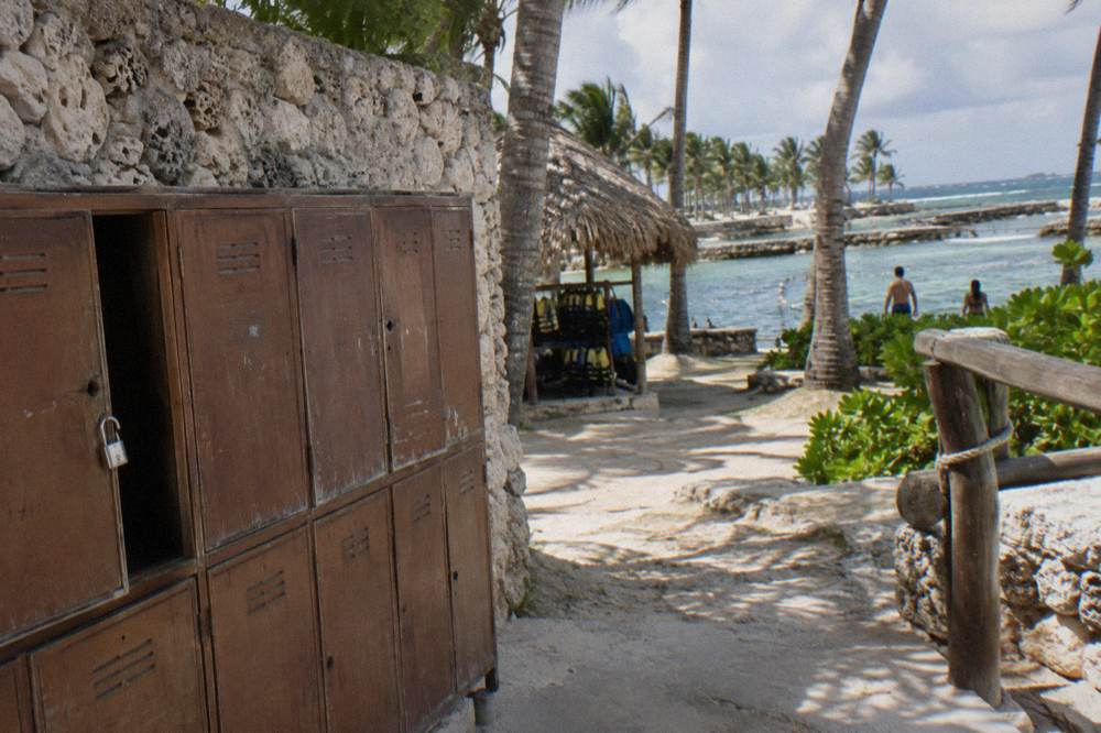 Wooden locker row beside a zipline base station under palm trees