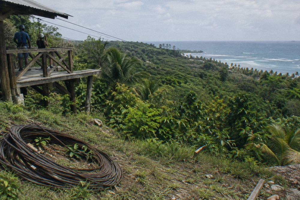 Wooden zipline platform with cables stretching over green jungle canopy