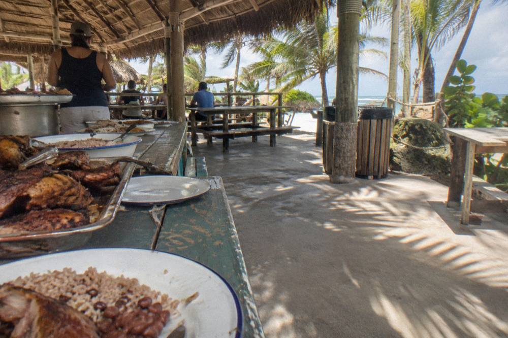 Dining table with a Dominican style buffet lunch set under an open sided ranch shelter