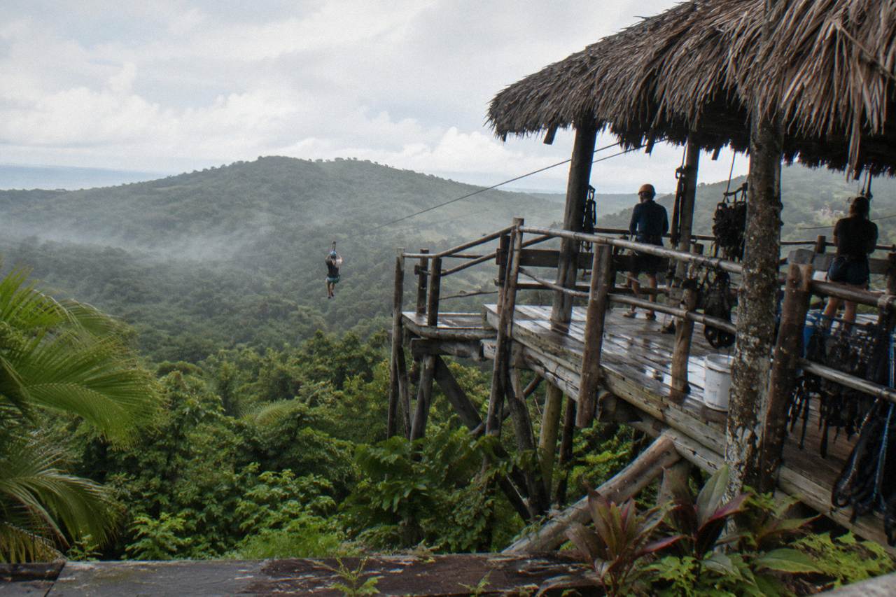 Treehouse-style zipline platform above dense jungle canopy in the Dominican Republic countryside