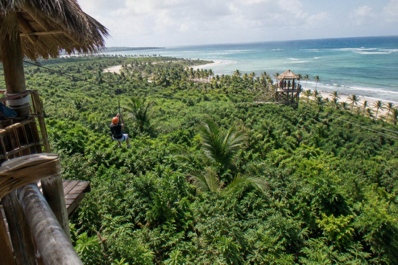 Zipline cables strung between wooden platforms above dense green jungle canopy in Punta Cana