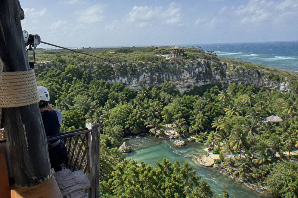 Tropical forest canopy seen from above with a thin steel cable crossing the gap