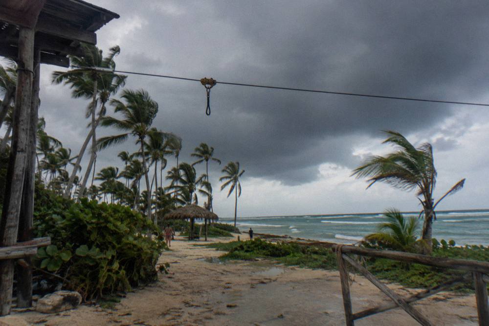 Dark rain clouds gathering over palm trees on a zipline course in the Dominican Republic