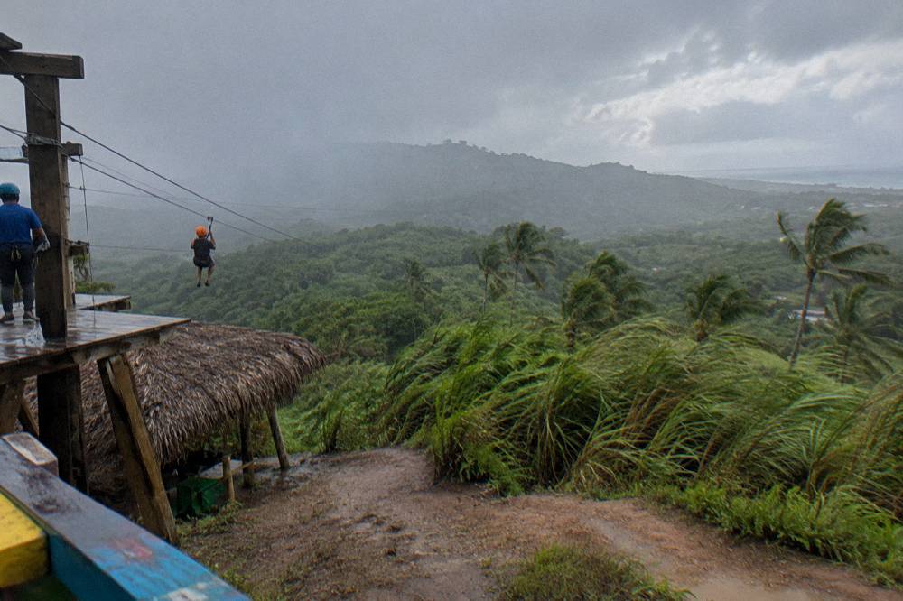 Tropical rainfall moving over green mountains inland from the Punta Cana coast